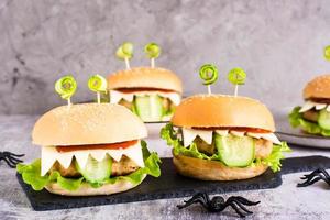 Monster burgers for halloween menu on slate and spiders. Home made creative food. photo