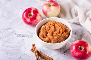 Homemade applesauce in a bowl and fresh fruit on the table. Organic food. photo