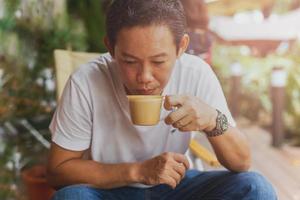 Caucasian man in jean and white t shirt drinking coffee break in the cafe. photo