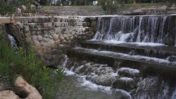 cachoeira artificial no meio de um parque de árvores e arbustos video