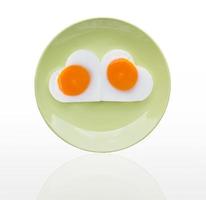 Fried egg  heart on green dish photo