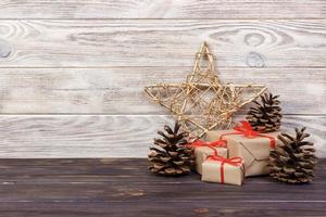 Christmas background with Christmas gift and star on wooden background with cones. Xmas and Happy New Year composition photo