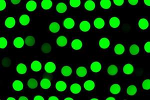 Unfocused abstract green bokeh on black background. defocused and blurred many round light photo