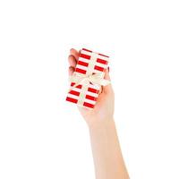 las manos de las mujeres dan Navidad envuelta u otro regalo hecho a mano en papel rojo con cinta dorada. aislado sobre fondo blanco, vista superior. concepto de caja de regalo de acción de gracias foto