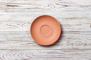 empty orange matte plate on wooden background photo