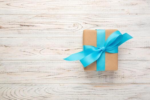 caja de regalo con lazo azul sobre mesa de madera blanca con espacio para copiar. vista superior foto