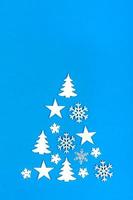 árbol de navidad creativo. árbol de navidad hecho de adornos navideños sobre fondo azul con espacio de copia vacío para texto foto
