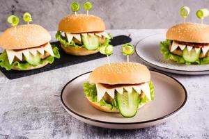 Homemade monster burgers with eyes and tongue for halloween menu on the table