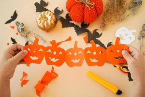 instrucciones paso a paso para crear guirnaldas de decoraciones de papel por parte de los niños para las vacaciones de halloween. paso 6 la guirnalda esta lista foto