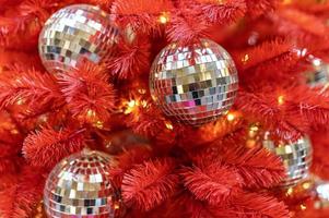 A red Christmas tree decorated with silver toys . Background with bokeh. New Year photo