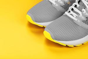 Gray sneakers on a yellow background sport concept, free space. photo