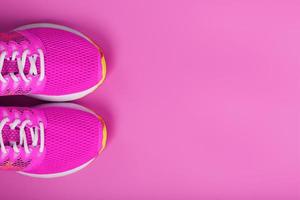 Sports pink sneakers on a pink background with free space. photo