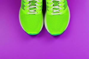 Green running shoes on a purple background. photo