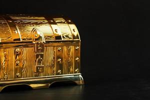 Gold treasure chest on a black textured background. photo