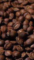 Vertical slow motion of roasted coffee beans falling. video