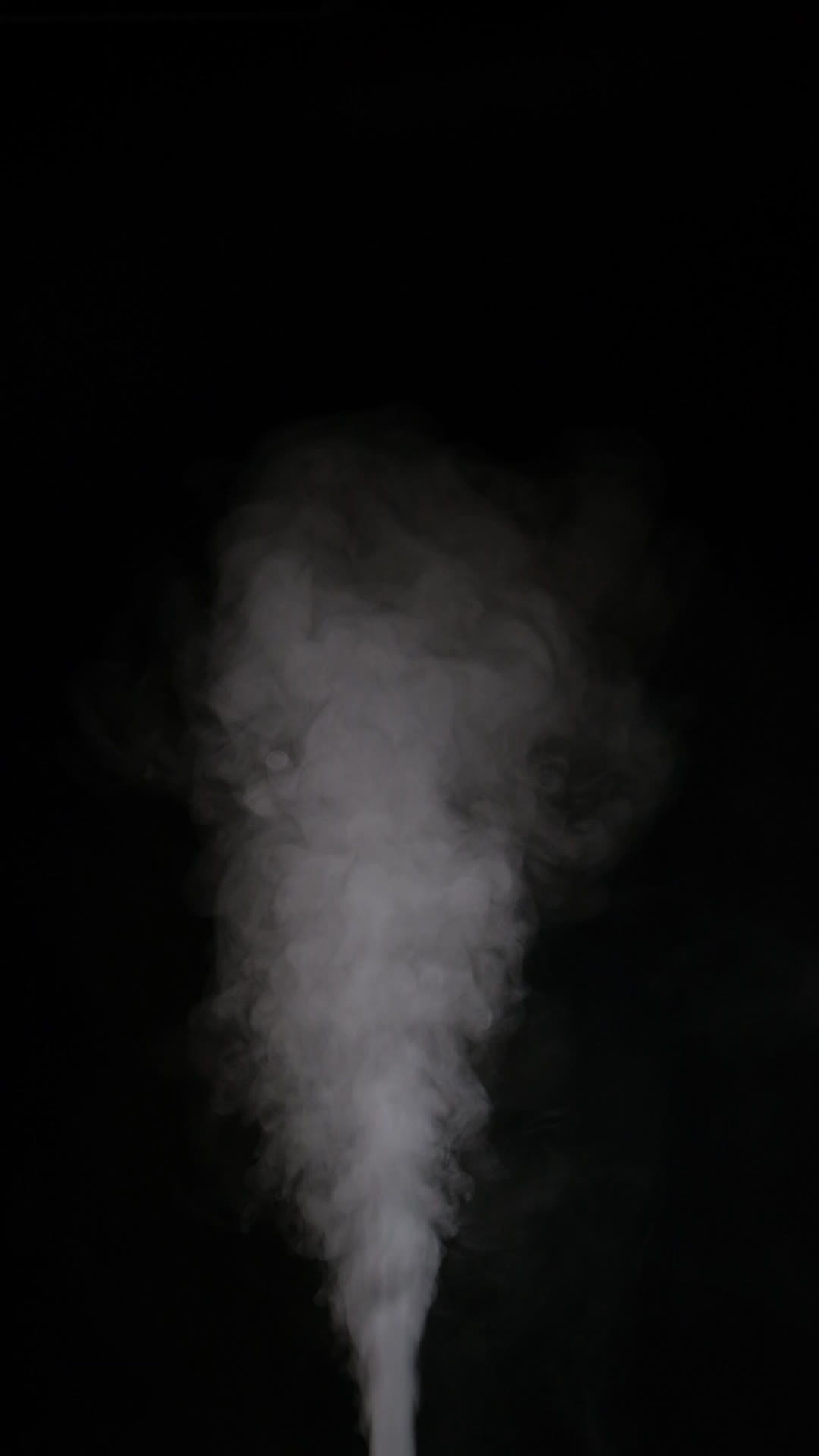 Slow motion vertical video of white smoke, fog, mist, vapor on a black ...