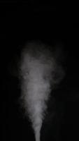 Slow motion vertical video of white smoke, fog, mist, vapor on a black background.