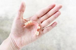 Dentures in the hands of women Healthy tooth concept for texture and background