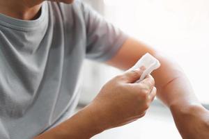 Asia man use medical cotton swab for cleaning and disinfection of wounds Cat scratch in First aid concept bleeding wounds photo