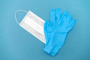 Surgical white mask and latex gloves for protection on a blue background photo