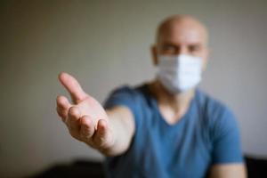 un hombre con una máscara médica tira de sus brazos hacia adelante foto