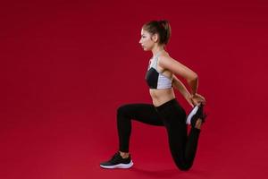 young woman is engaged in fitness on a red background photo