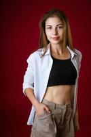 Portrait of a beautiful young woman  posing on a red background photo