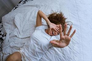 Overjoyed woman in pajamas stretching out her arms photo