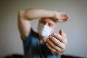 A man in a medical mask pulls his arms forward photo