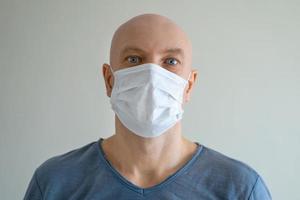 Close-up portrait of a bald man in a medical mask photo