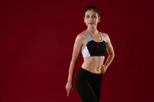 Young woman in sportswear on a red background photo