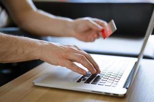 male hands hold credit card with laptop photo