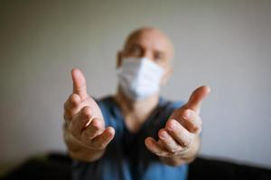 A man in a medical mask pulls his arms forward photo