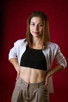 Portrait of a beautiful young woman  posing on a red background photo