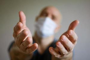 A man in a medical mask pulls his arms forward photo