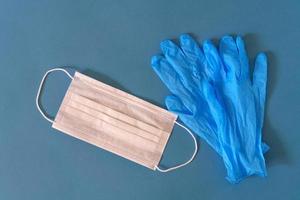 Medical mask and gloves on a blue background photo