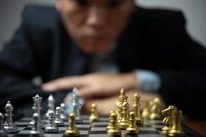 planificación estratégica y objetivos idea de negocio de éxito. hombre de negocios mirando ajedrez en el tablero. foto