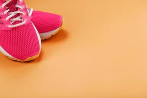 Sports sneakers, pink on a yellow background with free space. photo