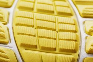 Textured design of the sole of the Tread of a sneaker in yellow Macro. photo