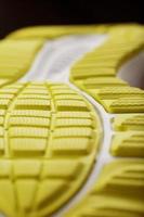 Close-up of the tread of a yellow sneaker, the textured pattern of the sole. photo