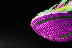 Textured pink sole of sports running shoes on a black background. photo