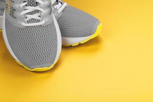 Gray sneakers on a yellow background with free space. photo