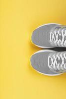 Gray sneakers on a yellow background with free space. photo