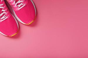 Sports pink sneakers on a pink background with free space. photo