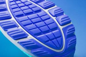Fragment of the sole of a blue sneaker close-up. Textured texture of the material of sports shoes. photo