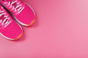 Sports pink sneakers on a pink background with free space. photo