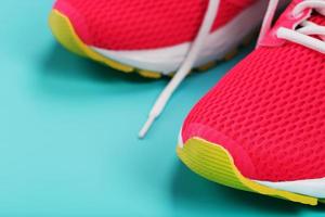 Pink sports sneakers for running on a blue background with free space. photo