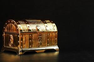 Gold treasure chest on a black textured background. photo