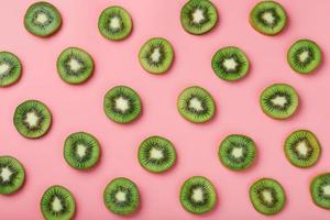 rodajas de kiwi maduras en patrones sobre un fondo rosa. foto