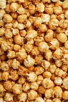 Caramel popcorn close-up as a background, full-screen texture. photo